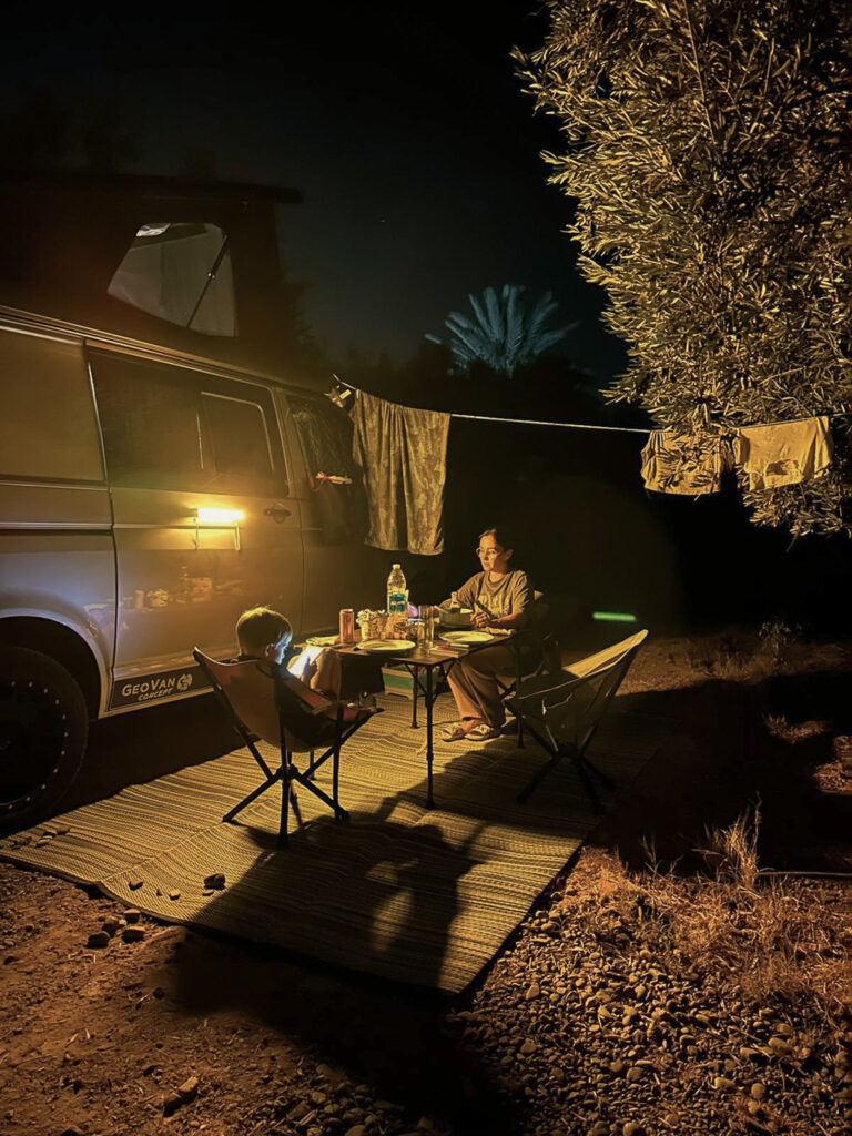Coin repas éclairé à côté du van, de nuit sous un olivier chez Saïda et Gérard au Maroc